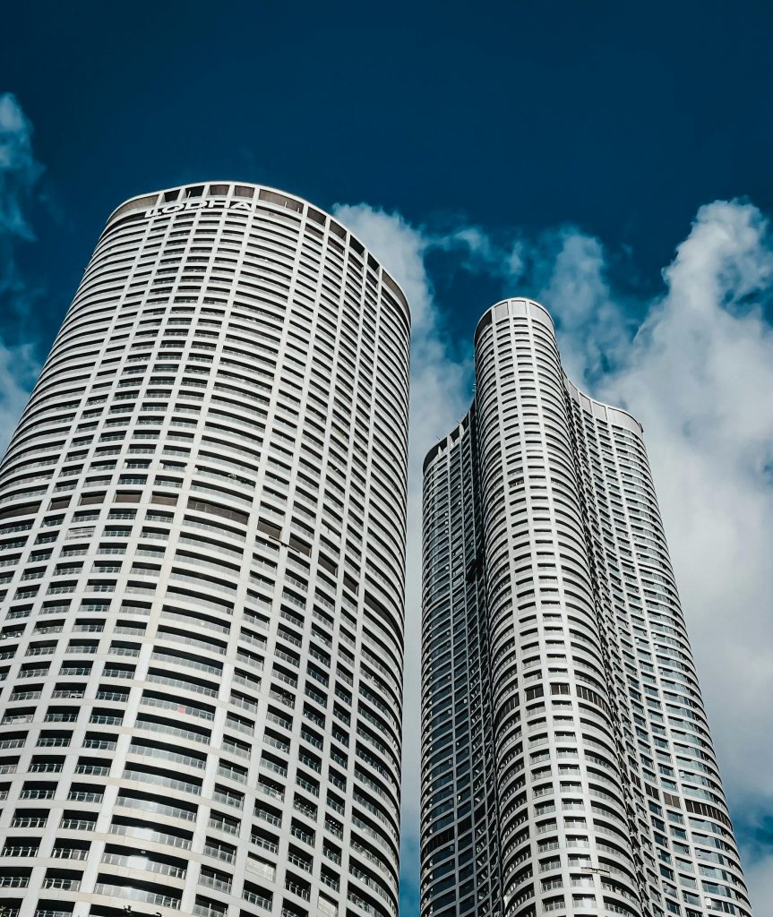 Low angle view of modern skyscrapers with a blue sky background, showcasing urban architecture.